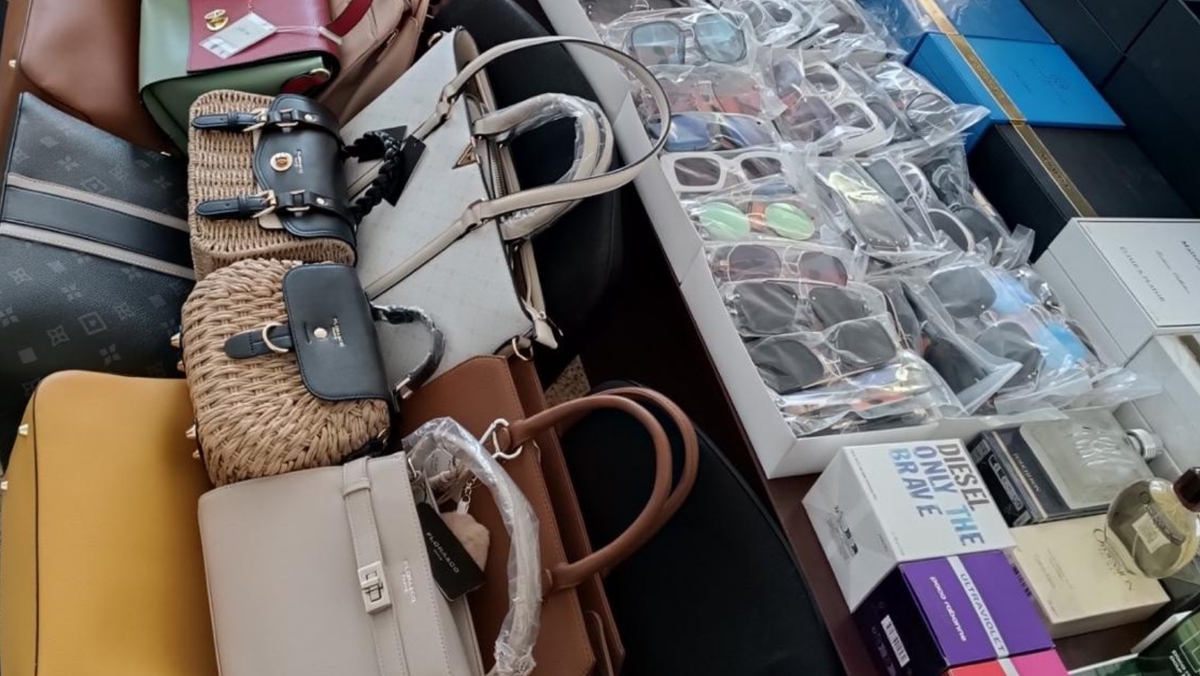 VIDEO/ Ce cumpărau moldovenii fără să știe? Genți, ochelari și parfumuri de „brand”, confiscate la Edineț