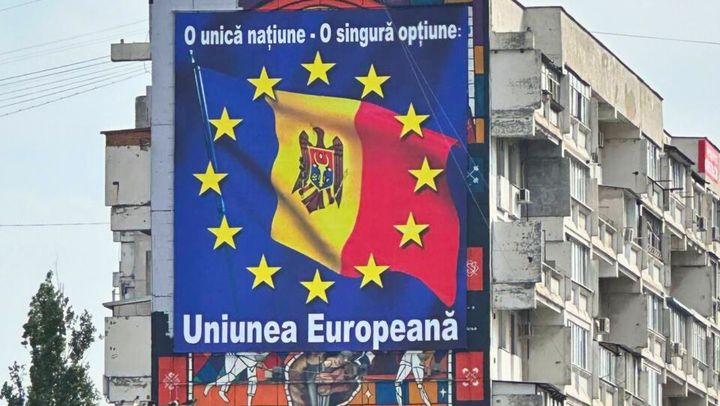 Pictura murală dedicată sportivilor olimpici, acoperită parțial cu un panou publicitar